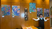 M. Wimmershoff vor 5 Kunstwerken in der Hotelllobby des Victor'S Residenz-Hotels Gera